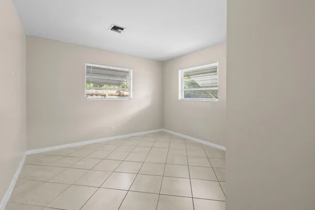 a view of an empty room with closet and a window