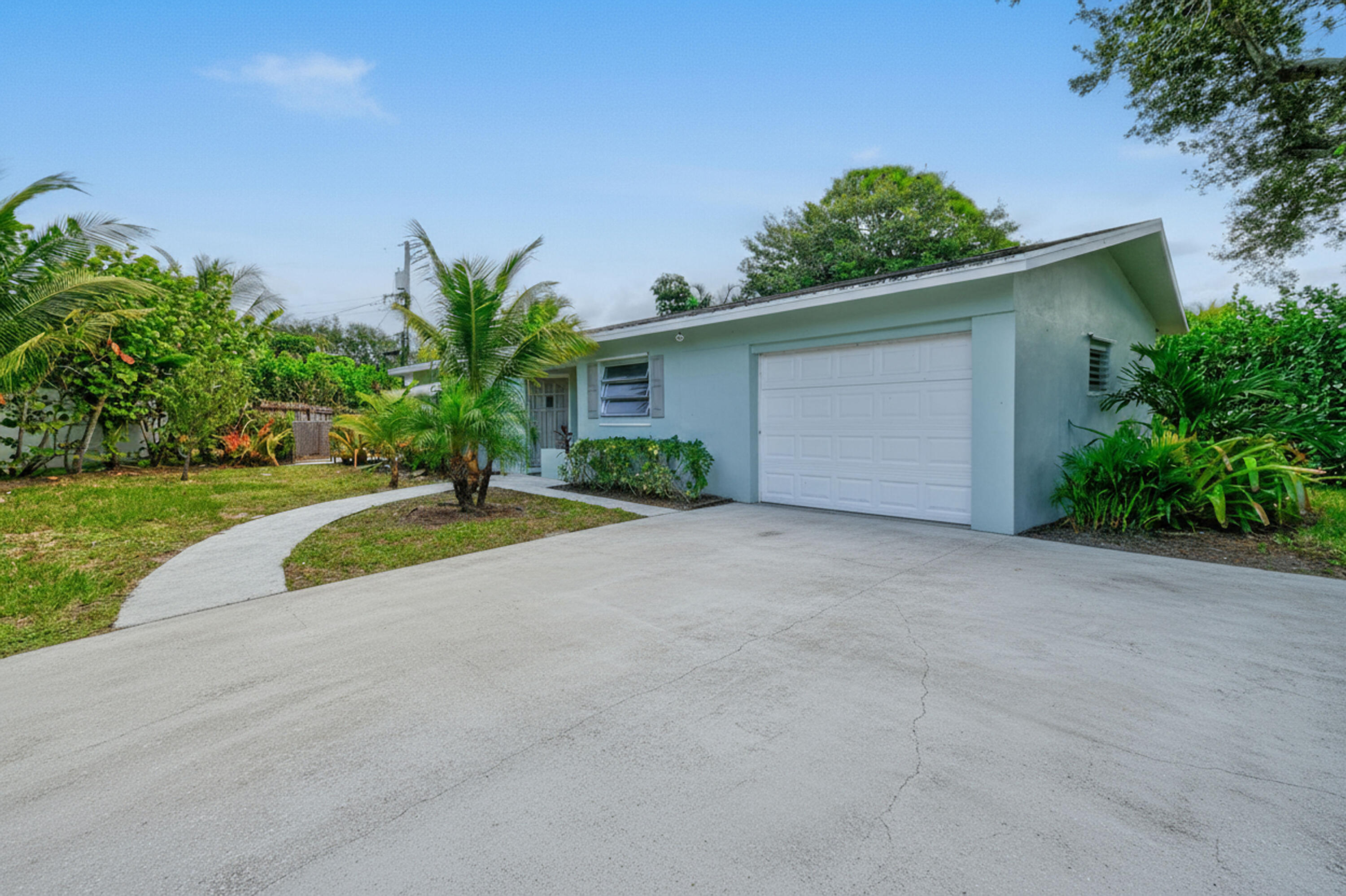 356 Cedar Avenue Tequesta, FL 33469 - Photo 3 of 51 front view of a house with a yard and potted plants