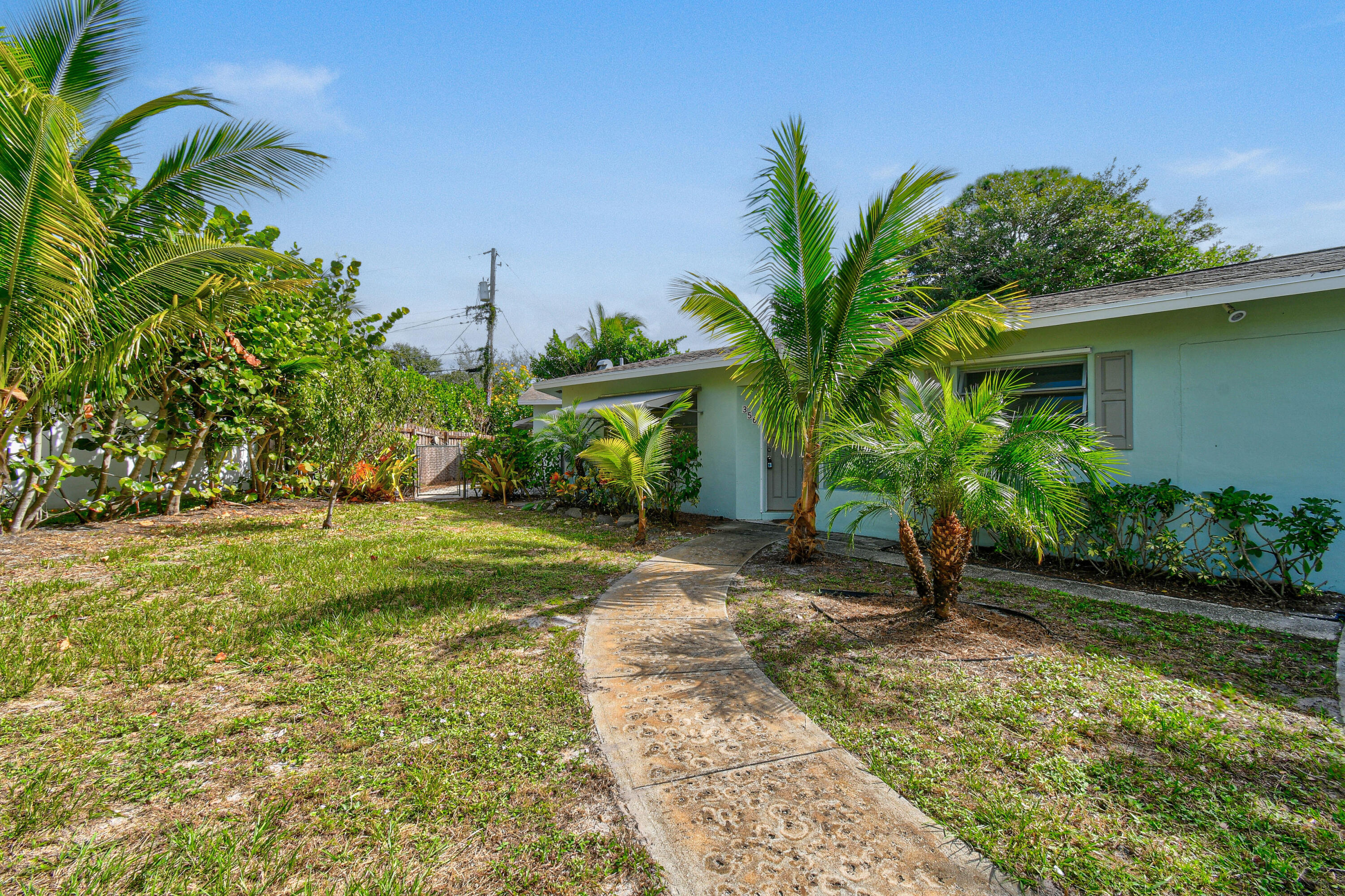 356 Cedar Avenue Tequesta, FL 33469 - Photo 4 of 51 a front view of a house with garden