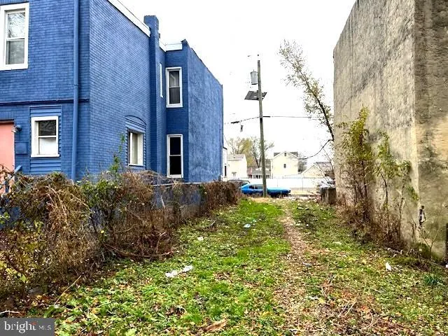a view of a brick house with a yard and large trees