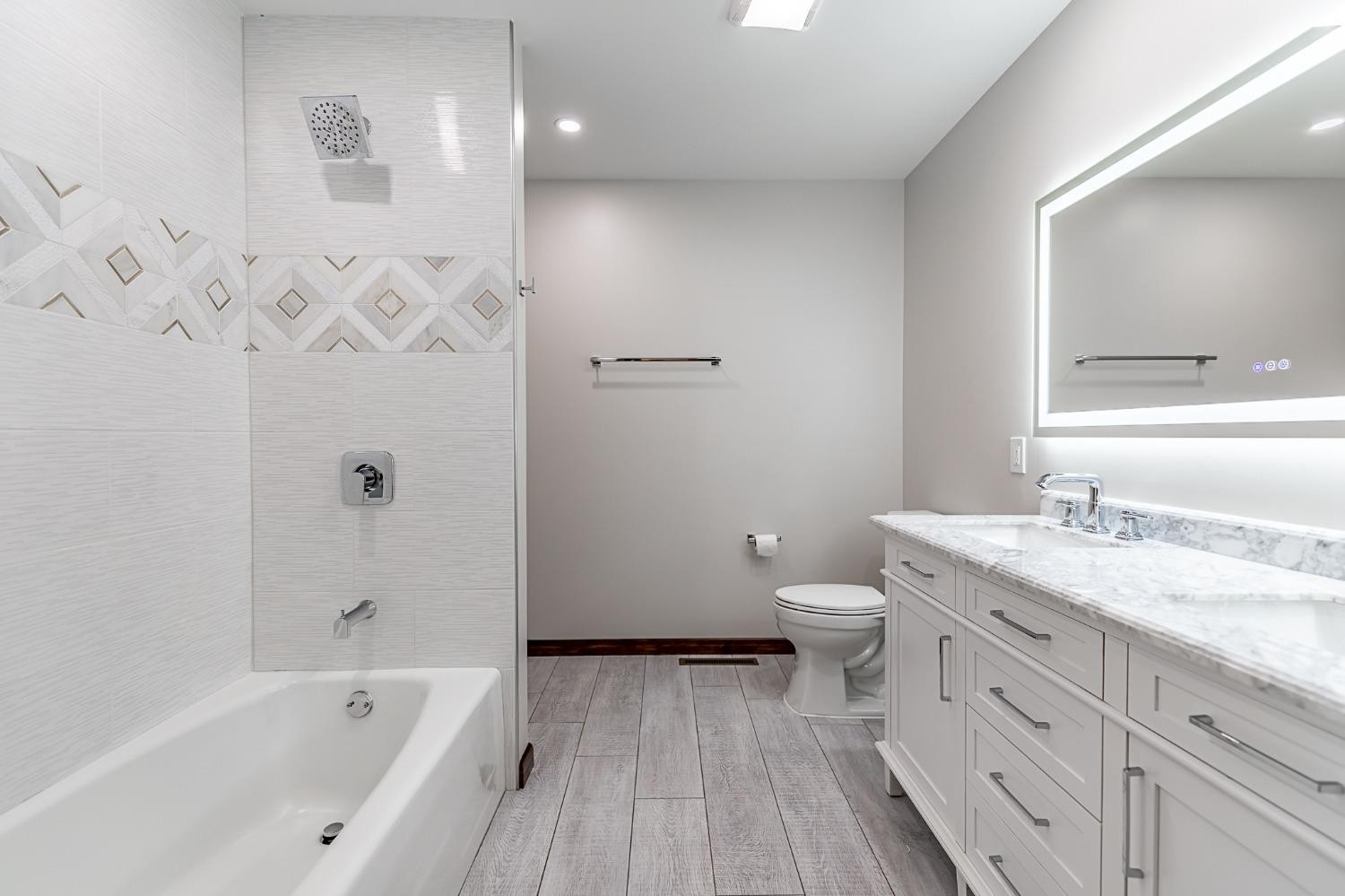 8551 Garfield Avenue Munster, IN 46321 - Photo 26 of 39 a bathroom with a granite countertop toilet a sink and a bathtub