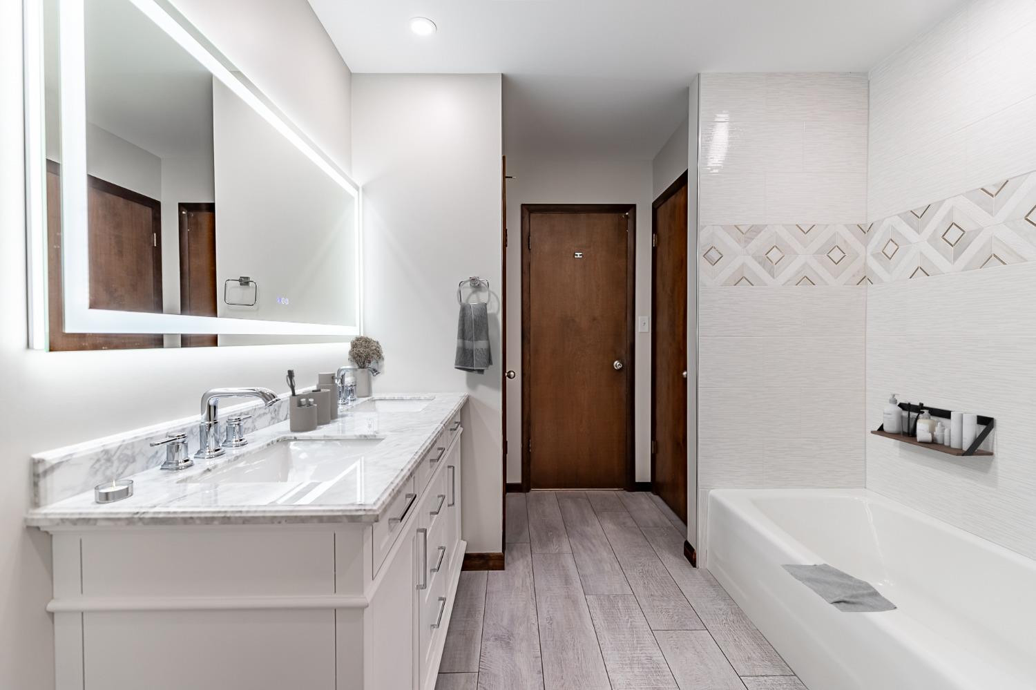 8551 Garfield Avenue Munster, IN 46321 - Photo 27 of 39 a bathroom with a granite countertop sink a bathtub a mirror and shower