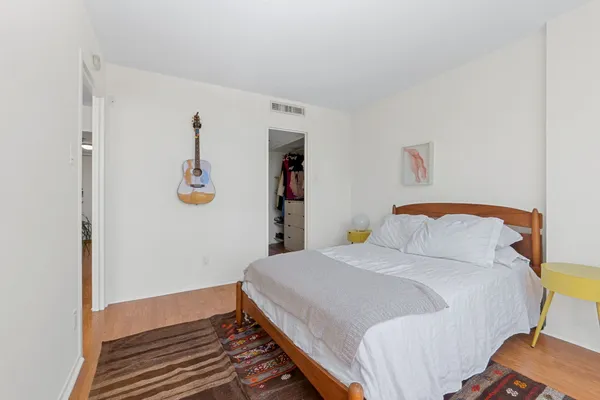 a bedroom with a bed and painting on the wall