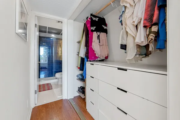 a view of walk in closet with clothes and shoes