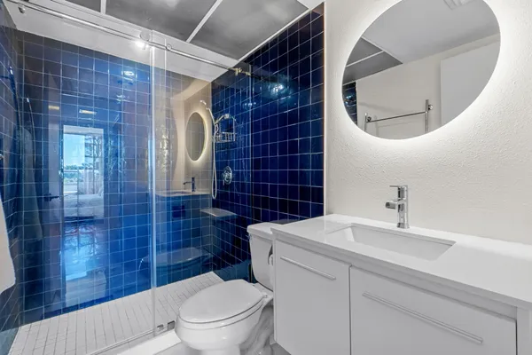 a bathroom with a sink a toilet and shower