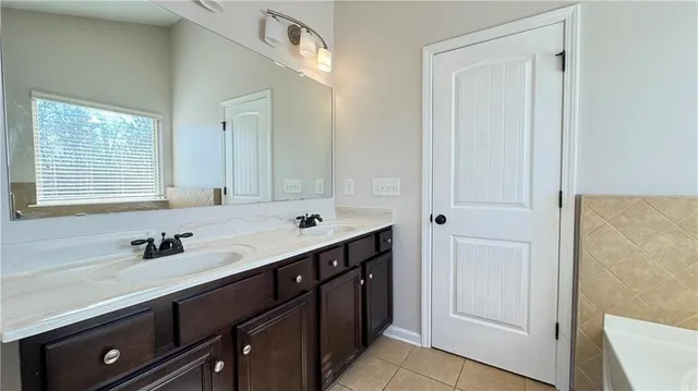 a bathroom with a tub sink and mirror