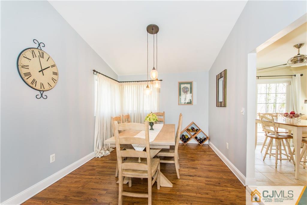 4 Peake Road Edison, NJ 08837 - Photo 6 of 25 a dining room with wooden floor a glass table and chairs