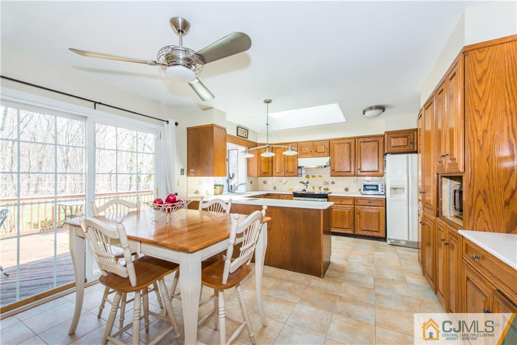 4 Peake Road Edison, NJ 08837 - Photo 9 of 25 a kitchen with stainless steel appliances kitchen island granite countertop a table chairs sink and cabinets