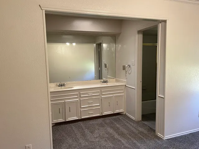 a bathroom with a double vanity sink and mirror