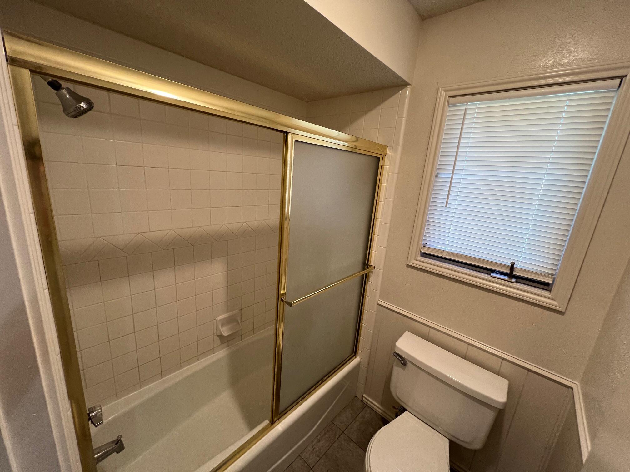 5522 95th Street Lubbock, TX 79424 - Photo 15 of 26 a bathroom with a shower and toilet