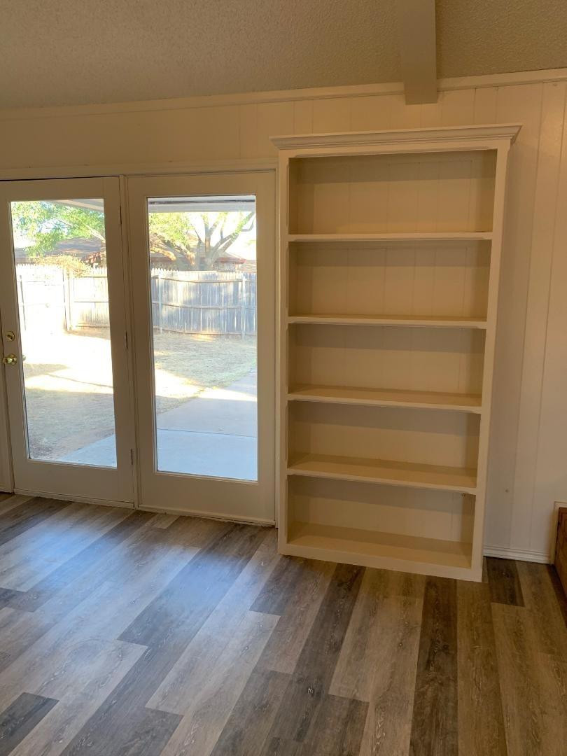 5522 95th Street Lubbock, TX 79424 - Photo 6 of 26 a view of an empty room with wooden floor and a window