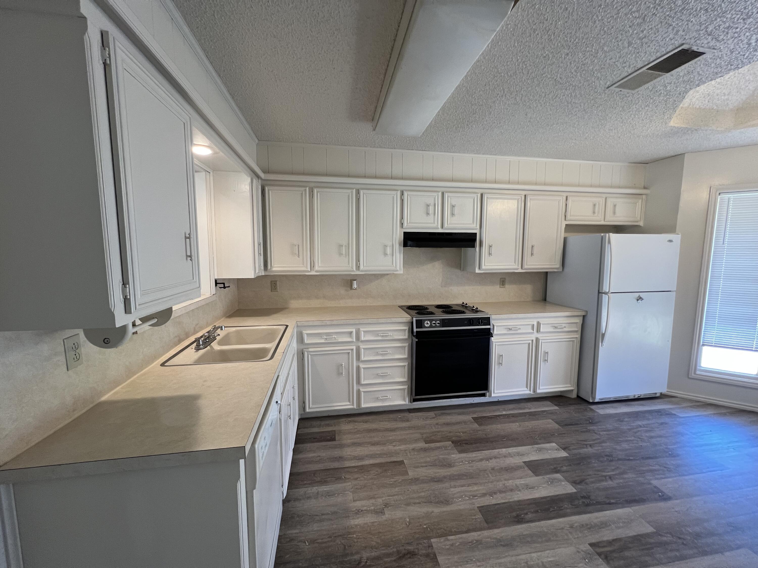 5522 95th Street Lubbock, TX 79424 - Photo 8 of 26 a kitchen with a sink stove top oven and refrigerator