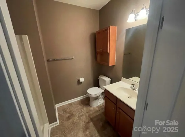 a bathroom with a sink and mirror with toilet