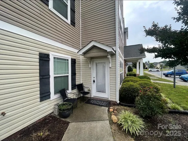 a view of a patio with chairs and potted plants