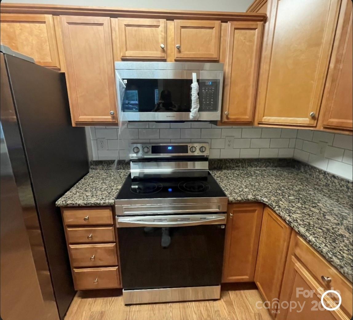 5430 Forester Drive High Point, NC 27265 - Photo 10 of 21 a kitchen with granite countertop a stove top oven microwave and cabinets
