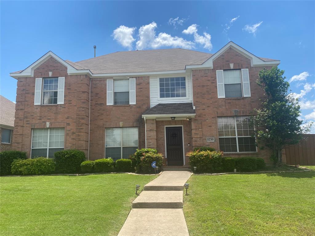 a front view of a house with a yard and a garden