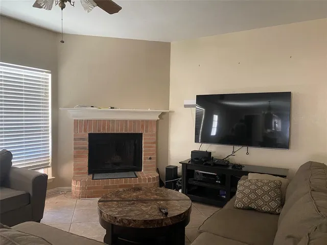 a view of an empty room with a fireplace and a window