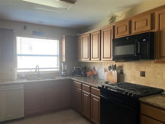 a kitchen with stainless steel appliances granite countertop a sink a stove and cabinets