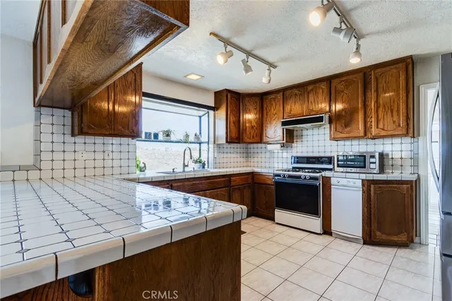 a bedroom with furniture a chandelier and a flat tv screen
