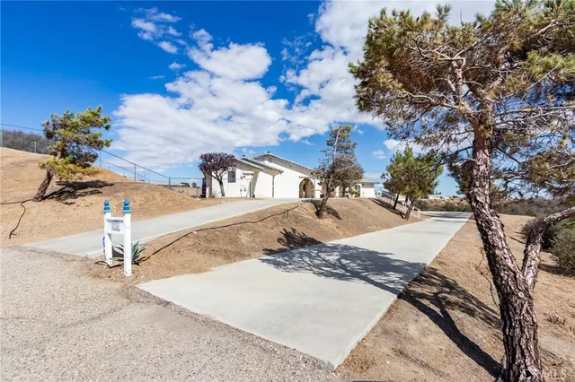 a view of a house with a yard and large trees