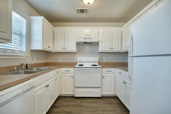 a kitchen with white cabinets and white appliances