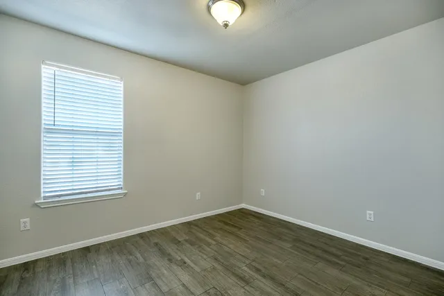 wooden floor in an empty room with a window