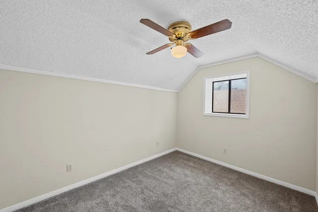 an empty room with window and fan