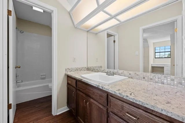 a bathroom with a granite countertop sink mirror and bathtub