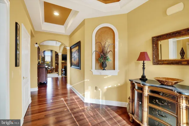 a view of a hallway with wooden floor and furniture
