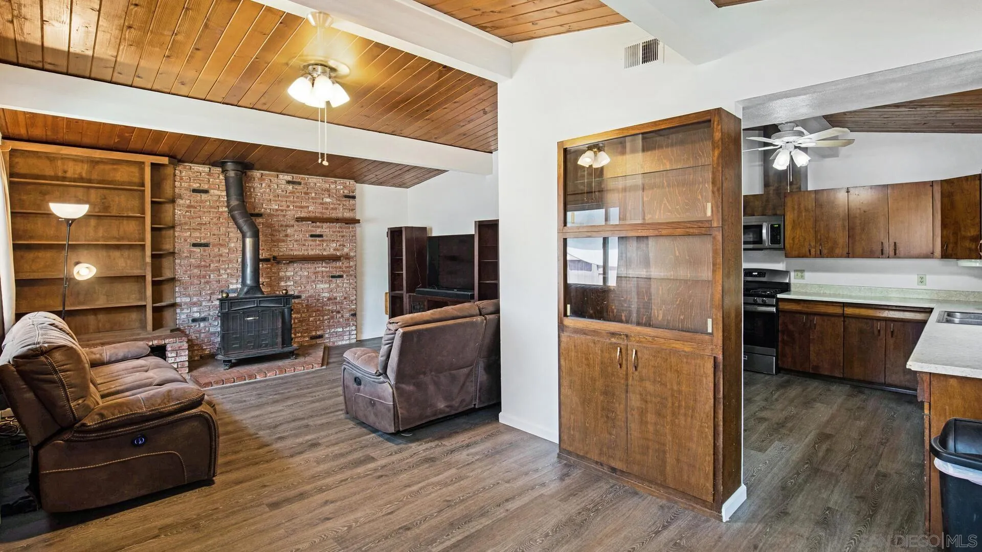 9243 Los Coches Road Lakeside, CA 92040 - Photo 10 of 30 a kitchen with stainless steel appliances a refrigerator a stove a sink and a dining table with wooden floor