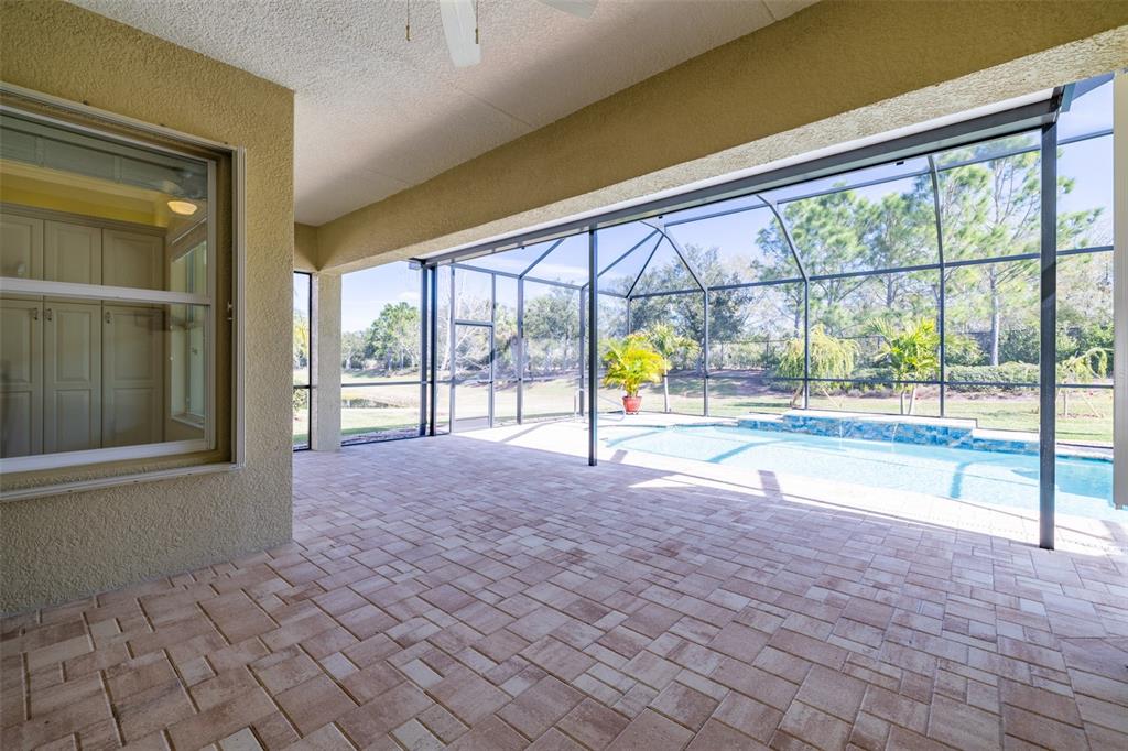 16122 Cedar Key Drive Wimauma, FL 33598 - Photo 39 of 98 a view of an empty room with a floor to ceiling window and a flat screen tv