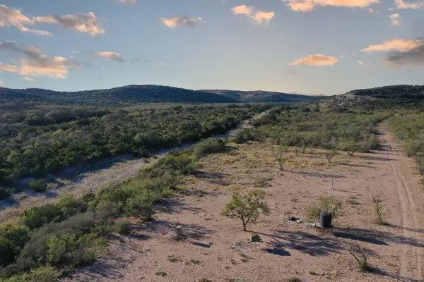 a view of a dry yard with mountains in the background