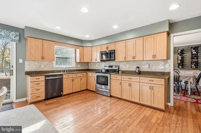 a kitchen with stainless steel appliances granite countertop a refrigerator stove microwave and sink