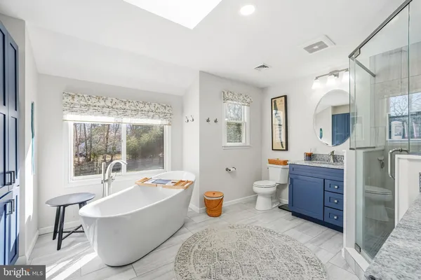 a bathroom with a tub sink and mirror