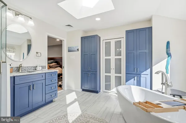 a spacious bathroom with a granite countertop sink mirror and a shower