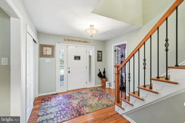 a view of an entryway with wooden floor and staircase