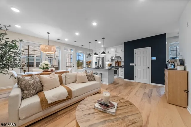 a kitchen with stainless steel appliances granite countertop a sink a stove and a wooden floors