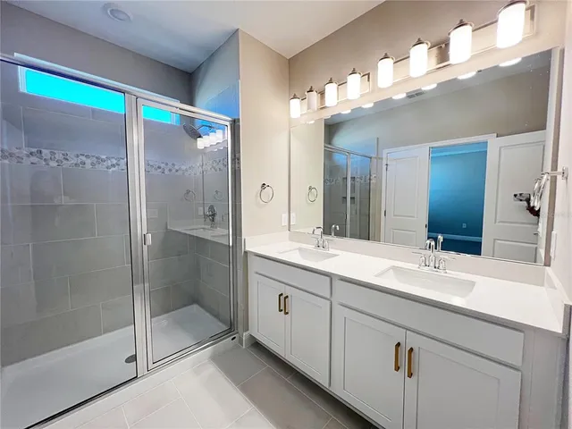 a bathroom with a double vanity sink mirror and shower