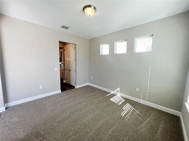an empty room with windows and closet
