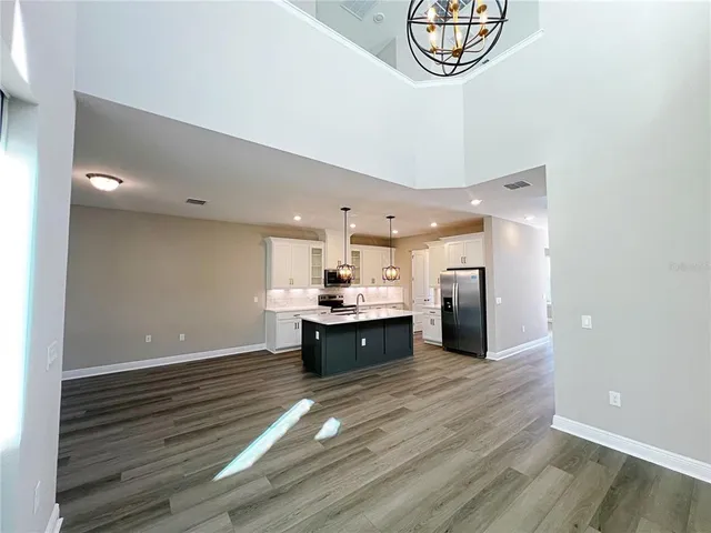 a large kitchen with kitchen island a stove top oven a sink and a counter space