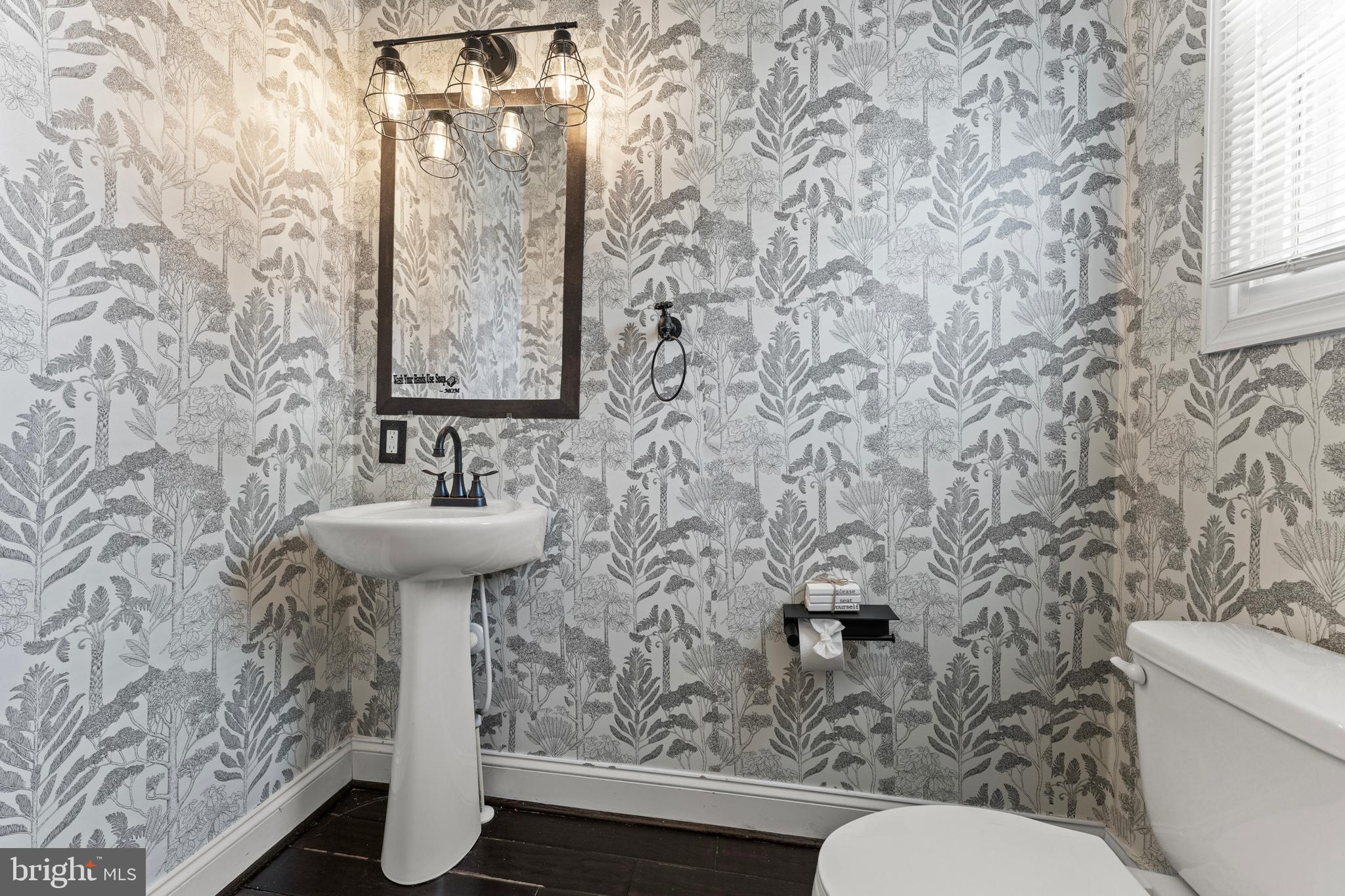 3616 Reisterstown Road Baltimore, MD 21215 - Photo 15 of 34 a bathroom with a sink toilet and mirror