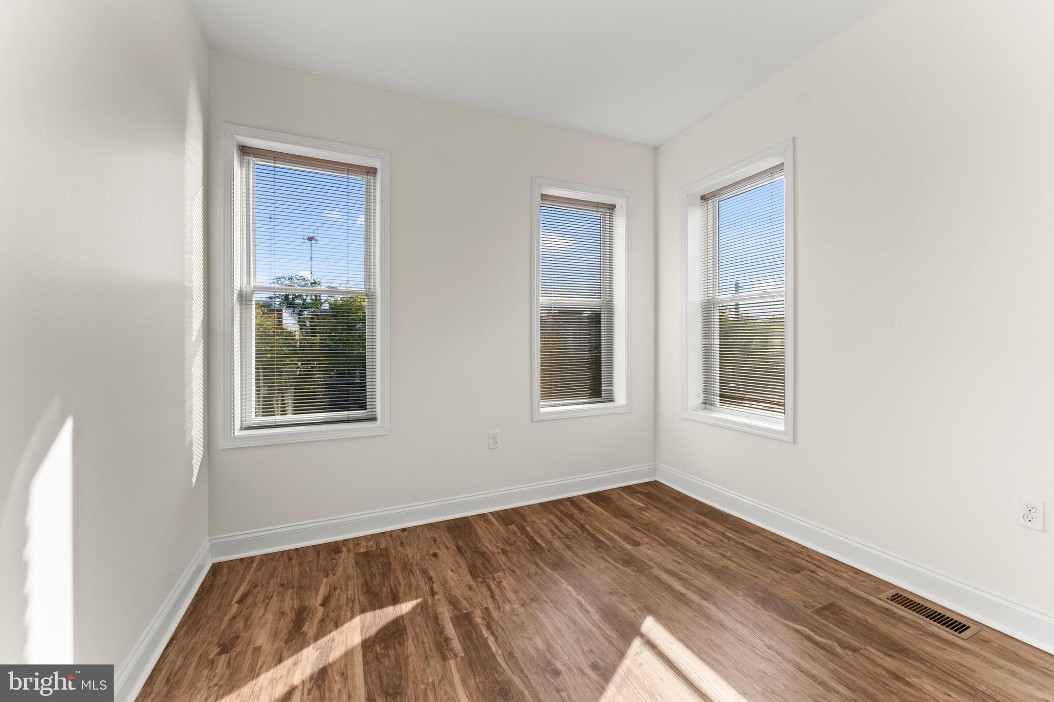 3616 Reisterstown Road Baltimore, MD 21215 - Photo 18 of 34 a view of an empty room with wooden floor and a window