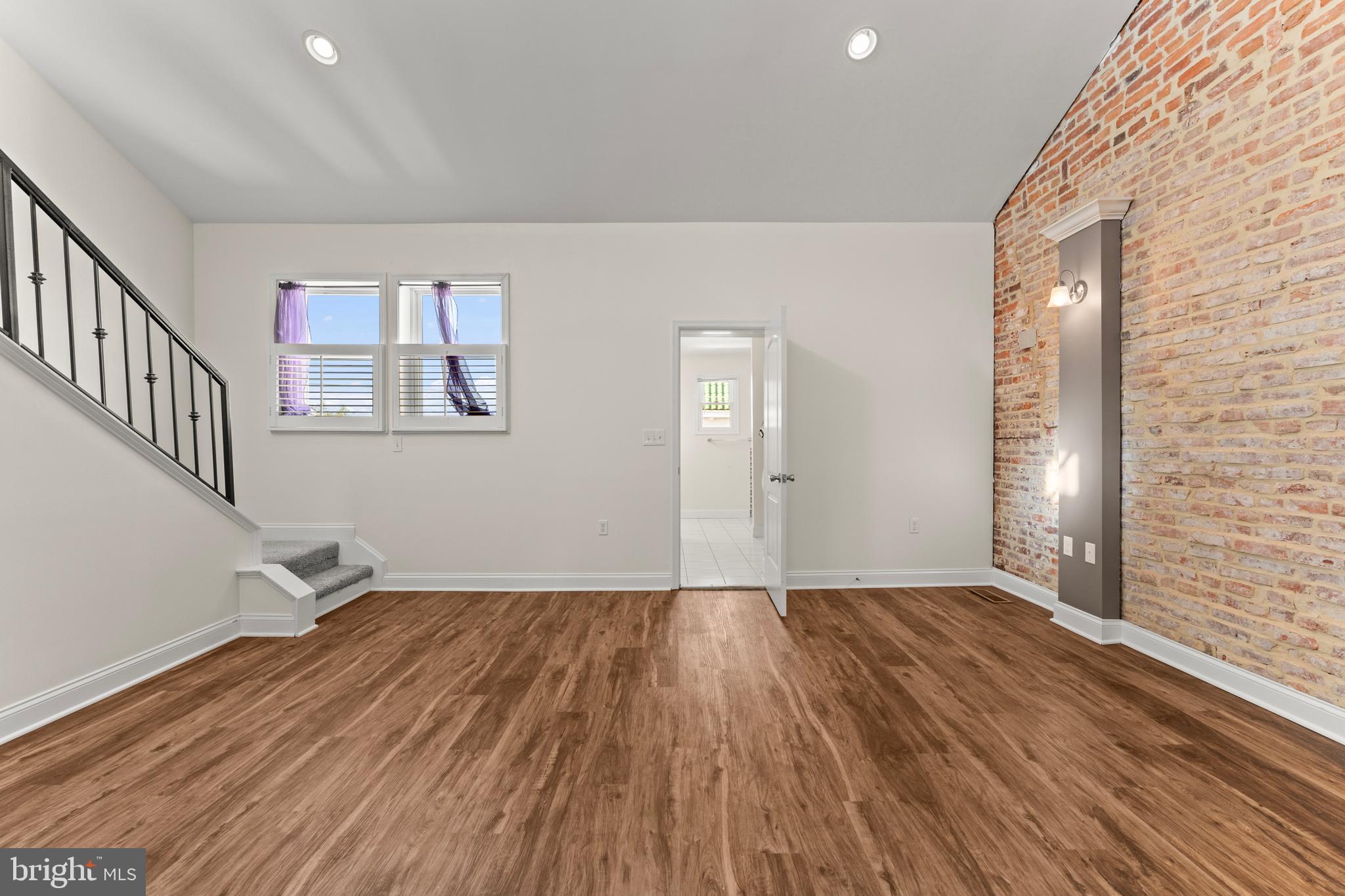3616 Reisterstown Road Baltimore, MD 21215 - Photo 22 of 34 a view of an empty room with wooden floor and a window