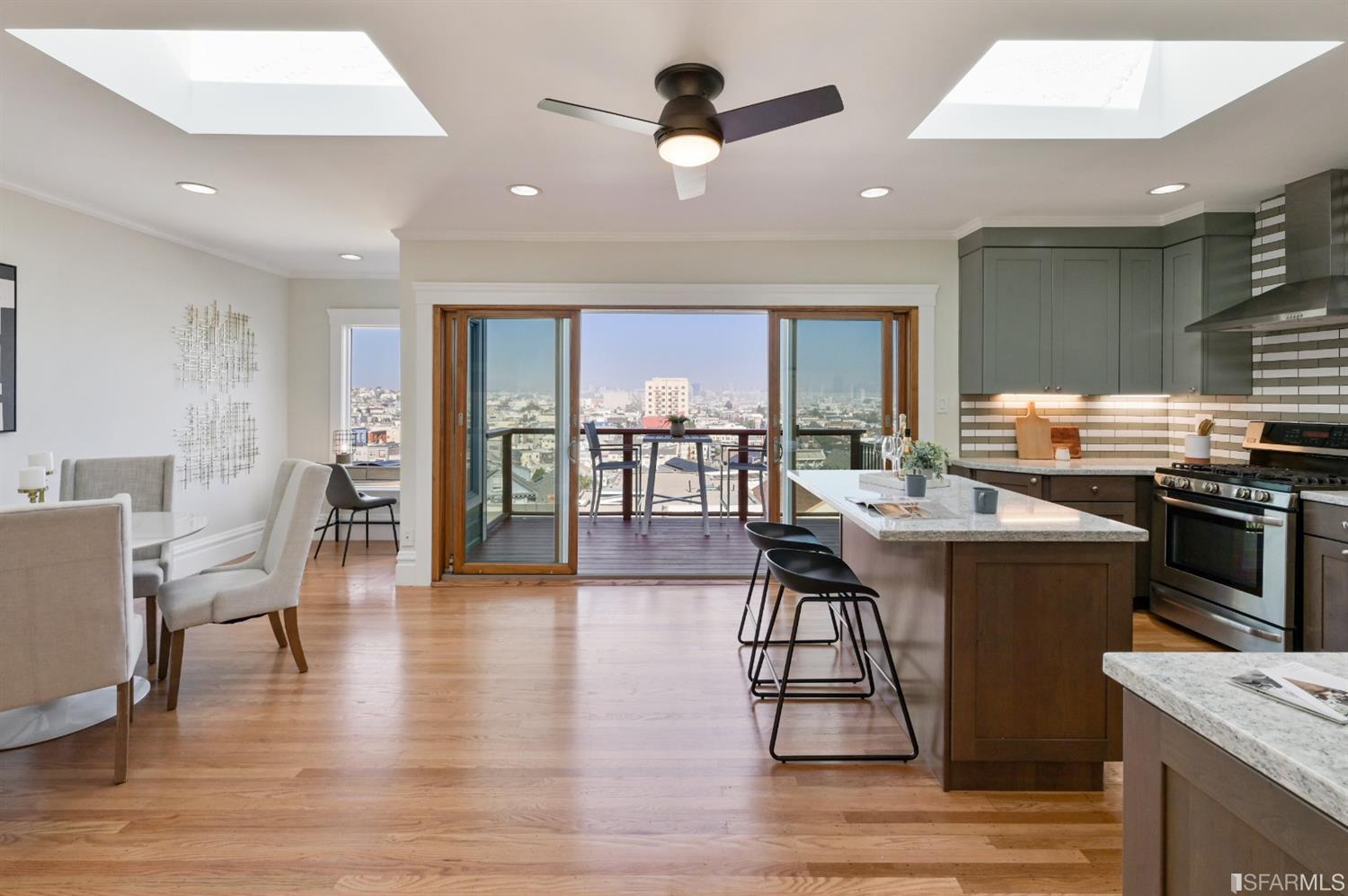 41 Montezuma Street San Francisco, CA 94110 - Photo 11 of 62 a open kitchen with stainless steel appliances granite countertop a stove top oven a sink a dining table and chairs with wooden floor