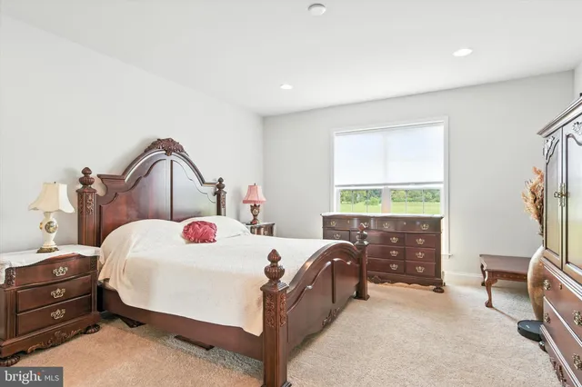 a bedroom with a bed a dresser and a window