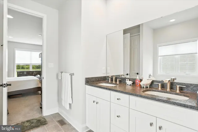 a bathroom with double vanity sinks a mirror and a bathtub