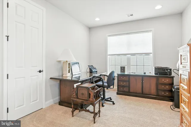 a view of a workspace with furniture and a window