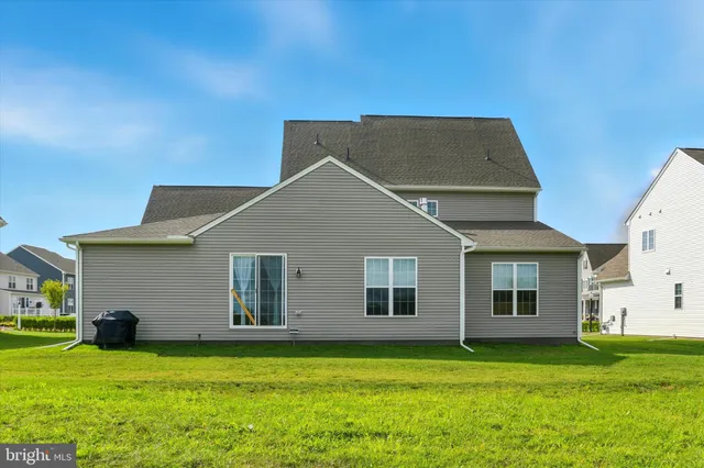 a backyard of a house with plants and wooden fence