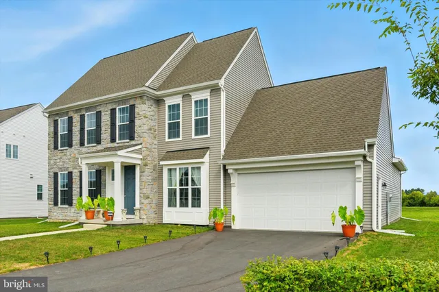 a front view of a house with a garden and yard