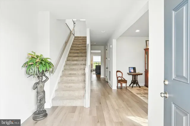 a view of a hallway with wooden floor and stairs
